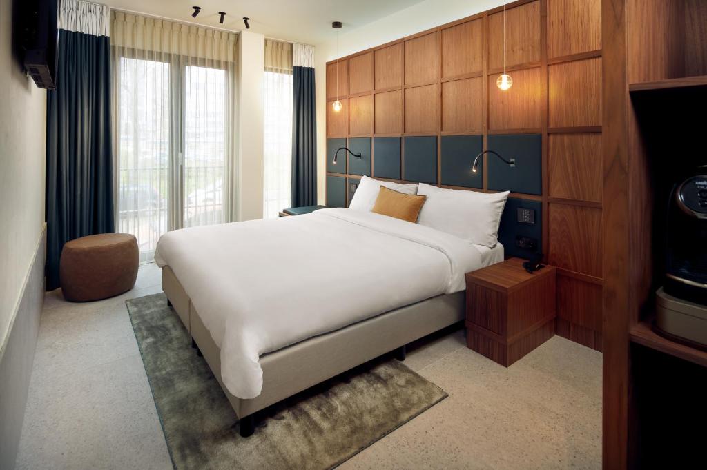 阿姆斯特丹Met Hotel Amsterdam的卧室配有一张白色大床和电视。