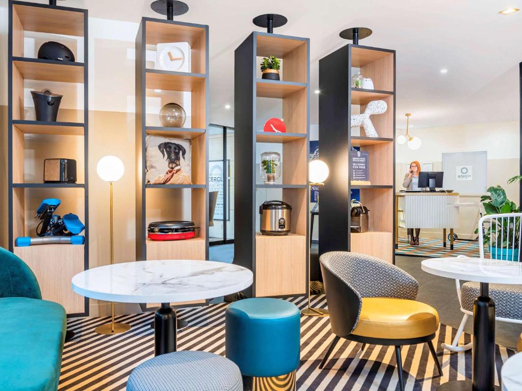 蒙鲁日巴黎蒙鲁爱达格公寓式酒店的配有桌椅和书架的房间