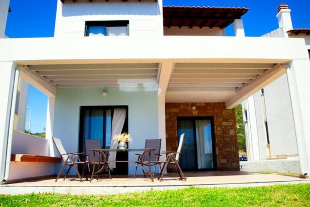 卡桑德里亚Beautiful villa-Ani's的房屋前设有带桌椅的天井。