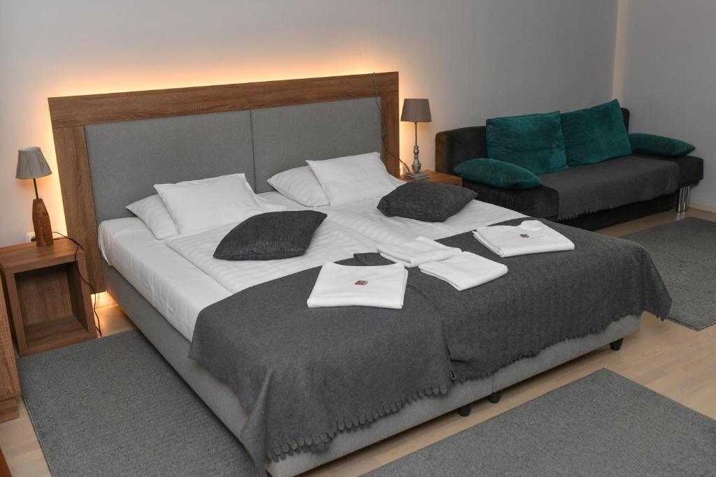 克塞洛Portré Apartman的一间卧室配有一张大床和毛巾