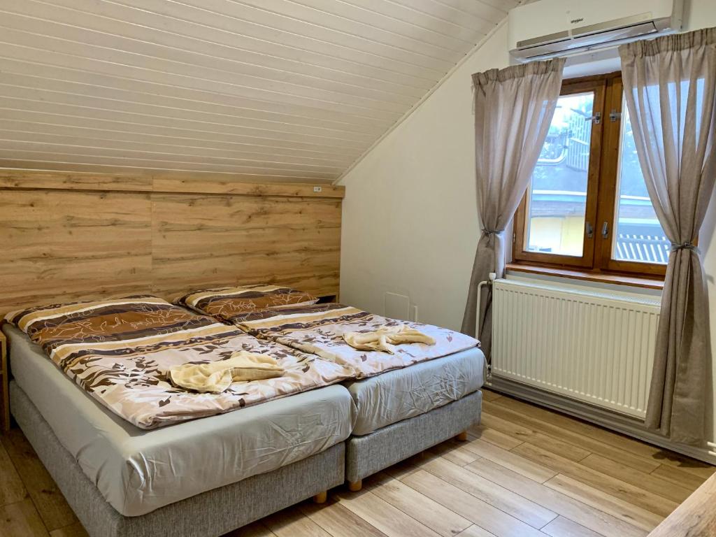 BojnáRanč pod Babicou的一间卧室设有一张大床和一个窗户。