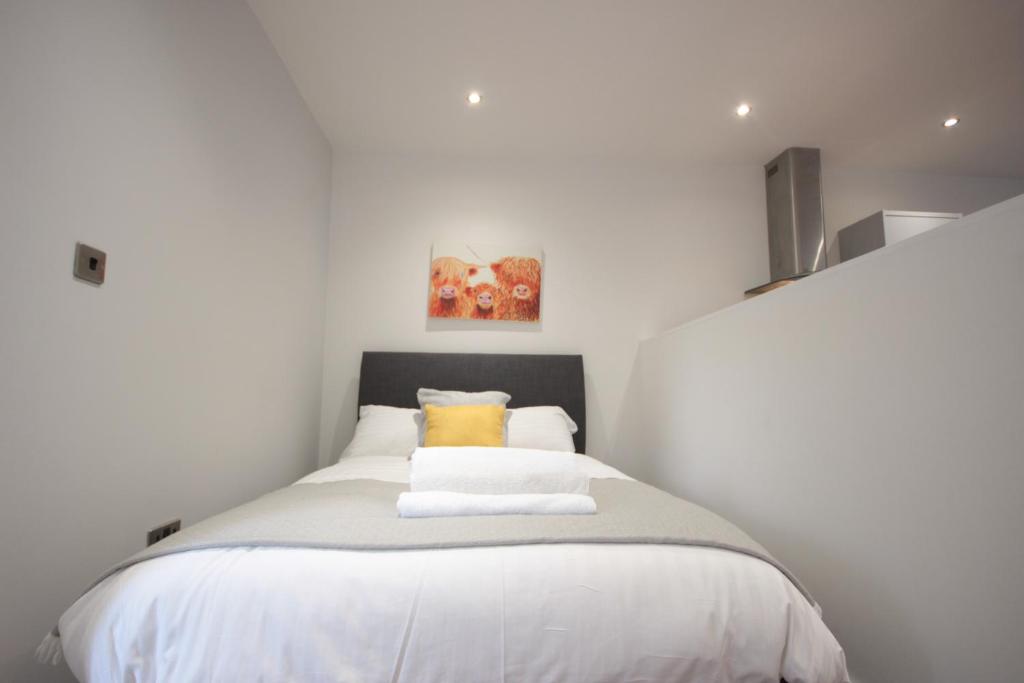 赫尔Studio 332的一间卧室配有带白色床单和黄色枕头的床。