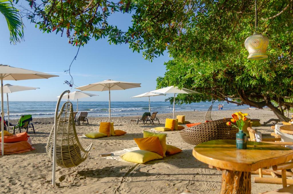 萨玛拉LA DOLCE VITA - on the Beach - Samara的海滩上摆放着桌椅和遮阳伞