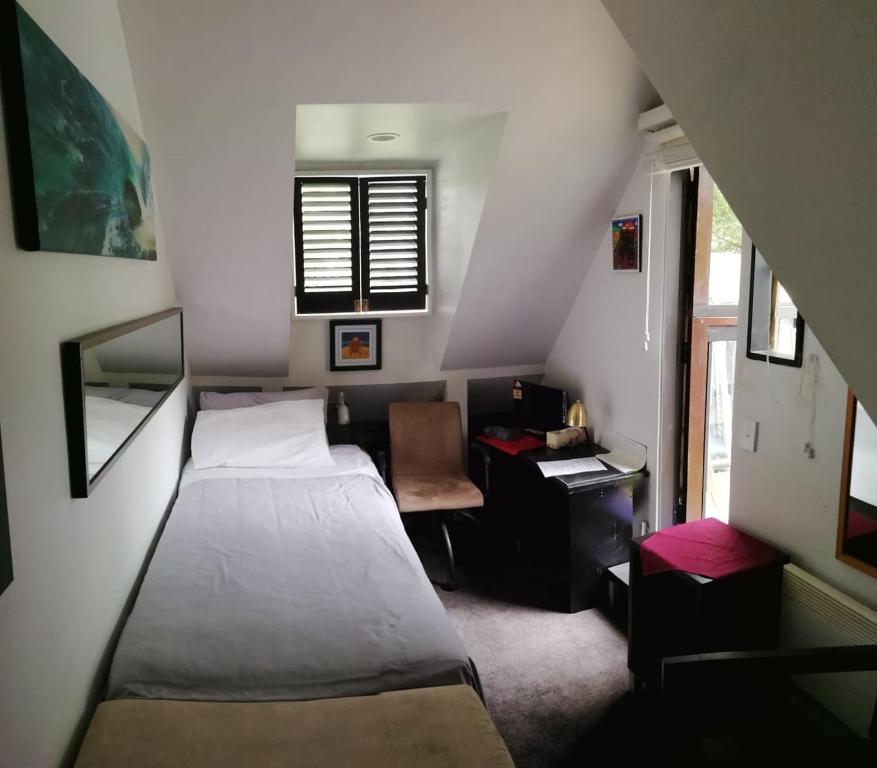 基督城Pryor Haven Chalet Green Retreat in a Lovely Place的一间小卧室,配有一张床和一张书桌
