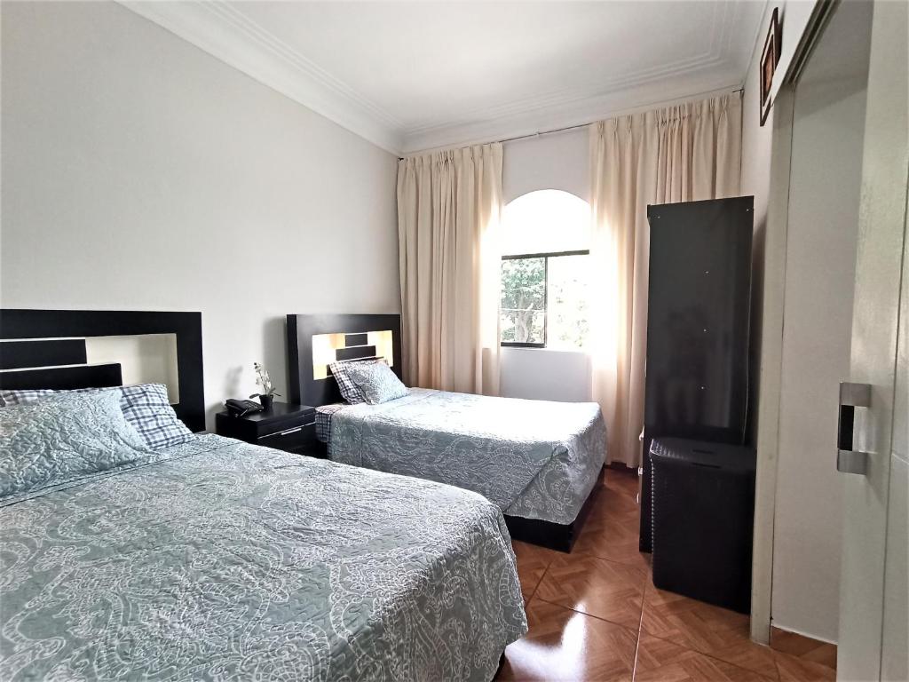 利马Lima Real Aparts的酒店客房设有两张床和窗户。