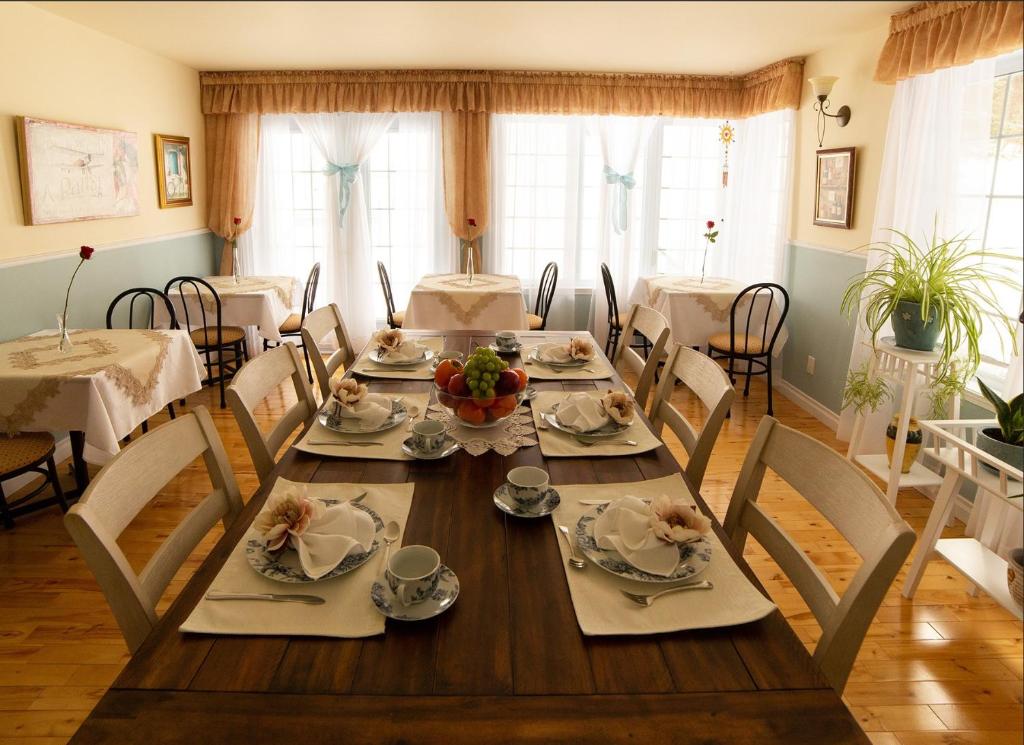 圣索弗尔-德斯蒙特Au coeur de Saint-Sauveur的一间带木桌和椅子的用餐室