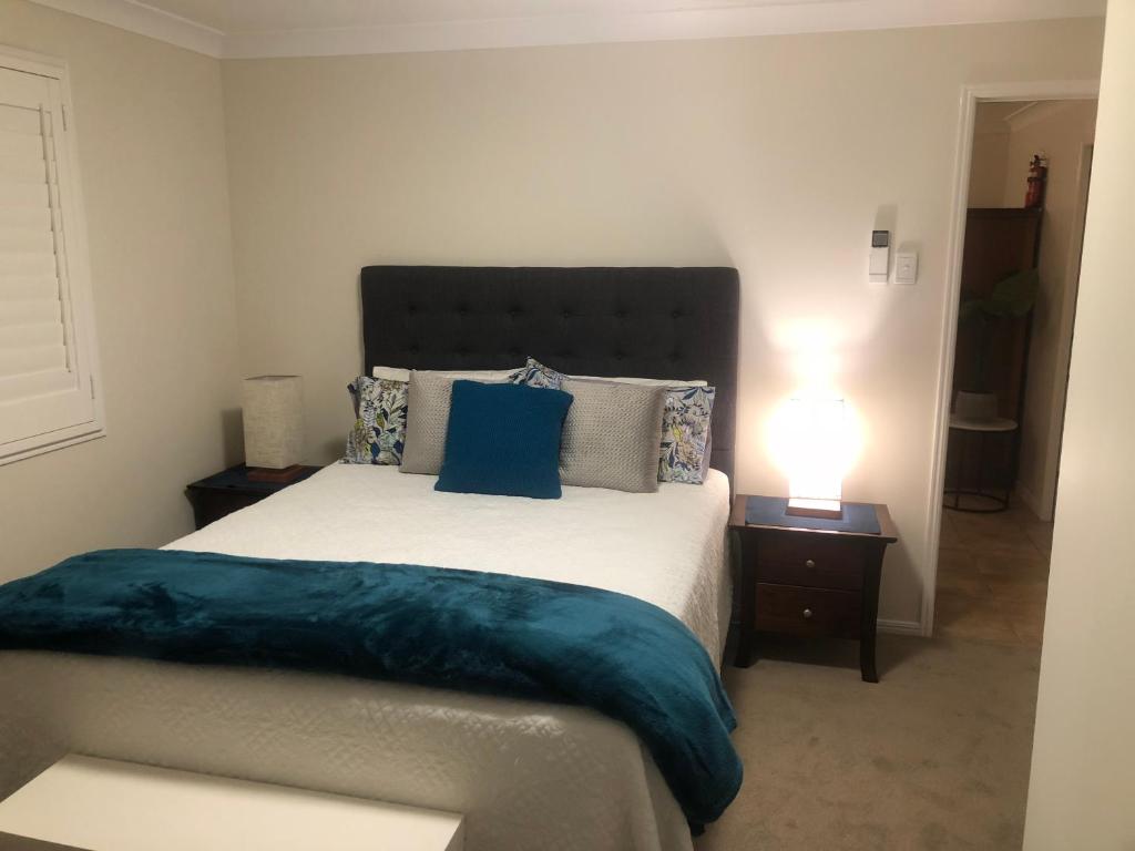 WoodfordWoodford Gardens的一间卧室配有一张带蓝色枕头的大床