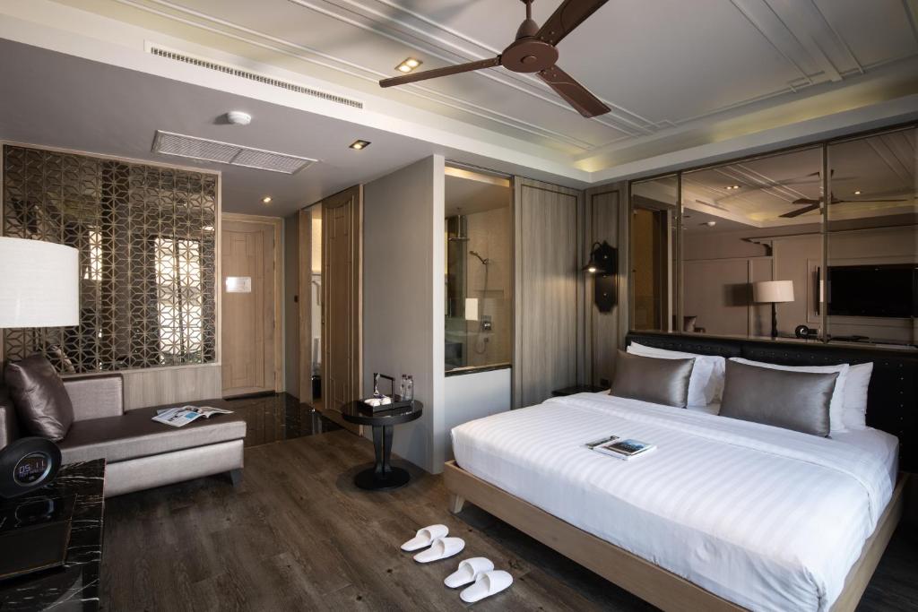 清迈De Chai the Deco Chiang Mai - SHA Plus的卧室配有一张白色的大床和一张沙发。