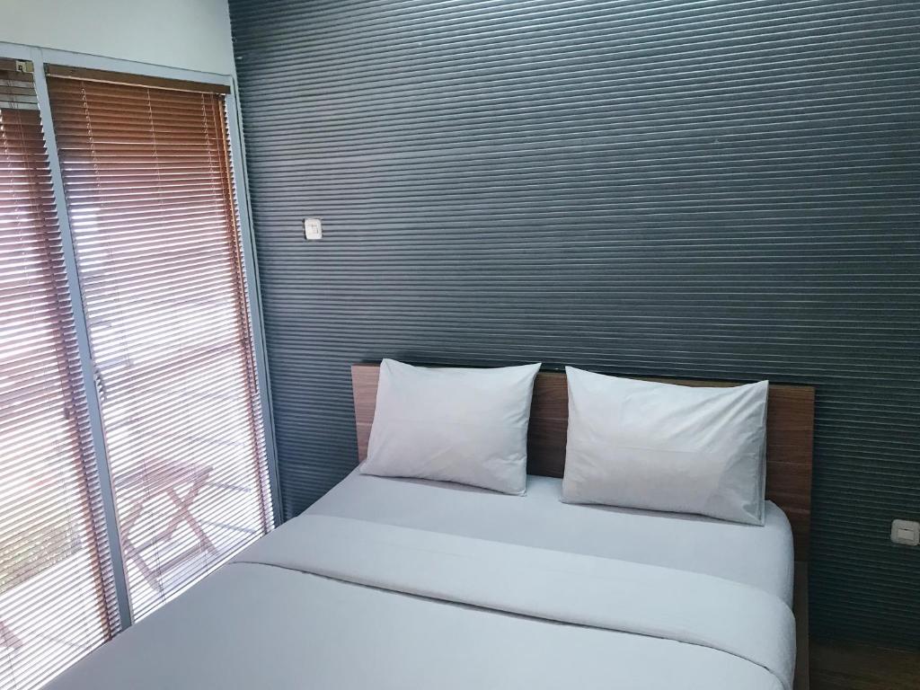 雅加达FLAT06 cipete的一间卧室配有带两个枕头的床和窗户