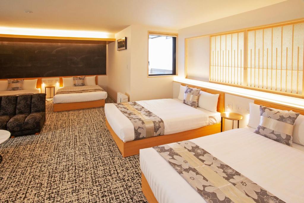 名古屋GRAND BASE Osu的酒店客房,设有两张床和一张沙发