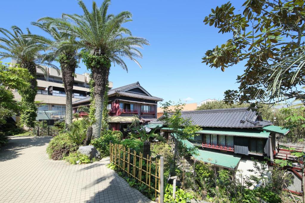 南房总市智库拉坎日式旅馆的前面有棕榈树的房子