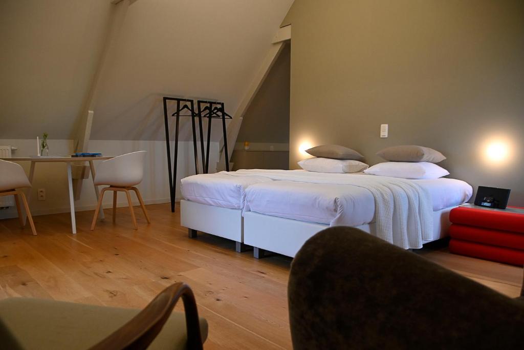 Horebeke克赛乐59住宿加早餐酒店的卧室配有一张带白色床单和枕头的大床。