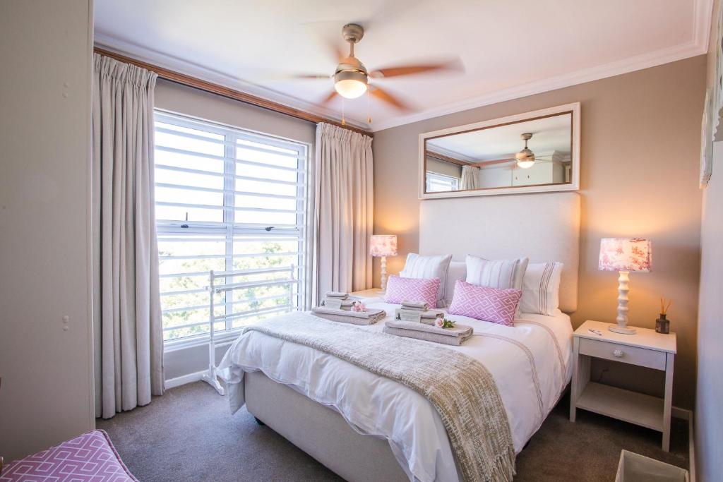 豪特湾dk villas 1 Harbour View Hout Bay的一间卧室设有一张大床和一个窗户。