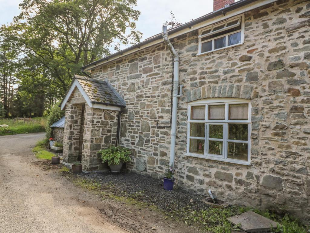 Llanbadarn-fynyddPreacher's Cottage的一座带窗户和棚子的古老石屋