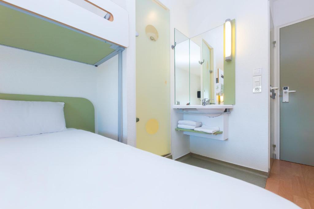 贝尔热拉克贝尔热拉克宜必思快捷酒店的卧室配有白色的床和镜子