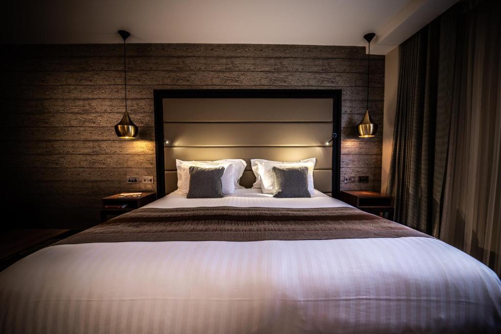 沃里克The Warwickshire Hotel and Country Club的一间卧室配有一张大床和两个枕头