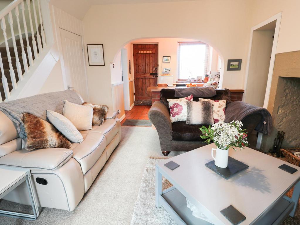 CheswickCorbett Cottage的客厅配有沙发和桌子