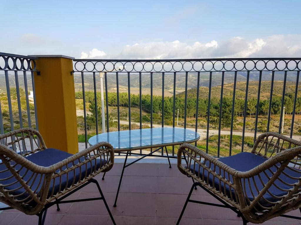阿尔热祖尔Cozy apartment in Algarve West Coast - Aljezur (2 min da Praia Monte Clérigo)的阳台配有2把椅子和1张桌子,享有风景。
