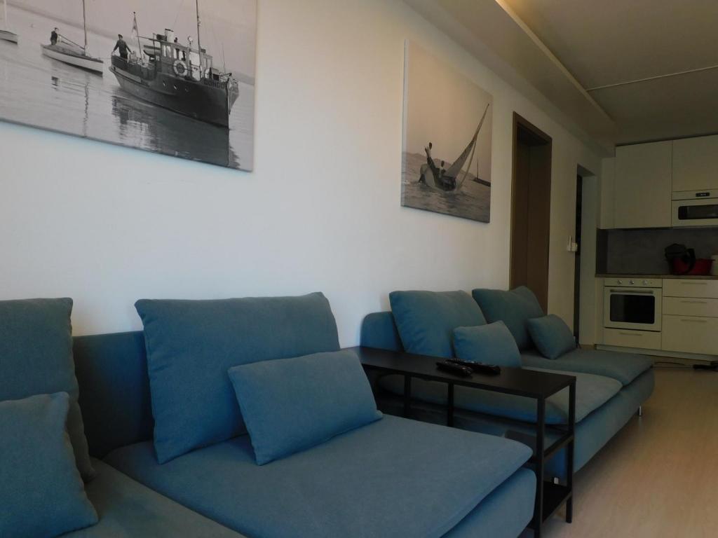 希欧福克K&K Apartment Siófok的客厅配有蓝色的沙发和桌子
