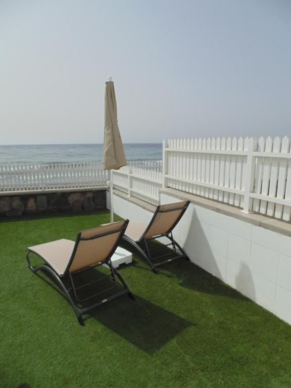 圣阿古斯丁迈阿密海滩简易别墅酒店的阳台上配有两把椅子和一把遮阳伞,