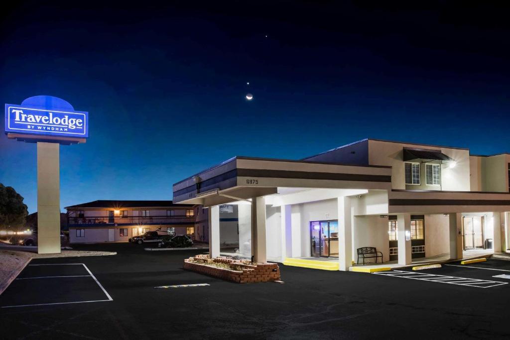 科罗拉多斯普林斯Travelodge by Wyndham Colorado Springs Airport/Peterson AFB的停车场有标志的酒店