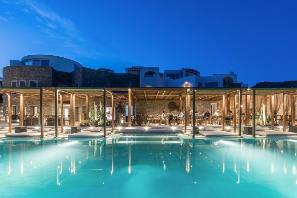 圣斯特凡诺斯Rocabella Mykonos Hotel的夜间带游泳池的建筑的 ⁇ 染