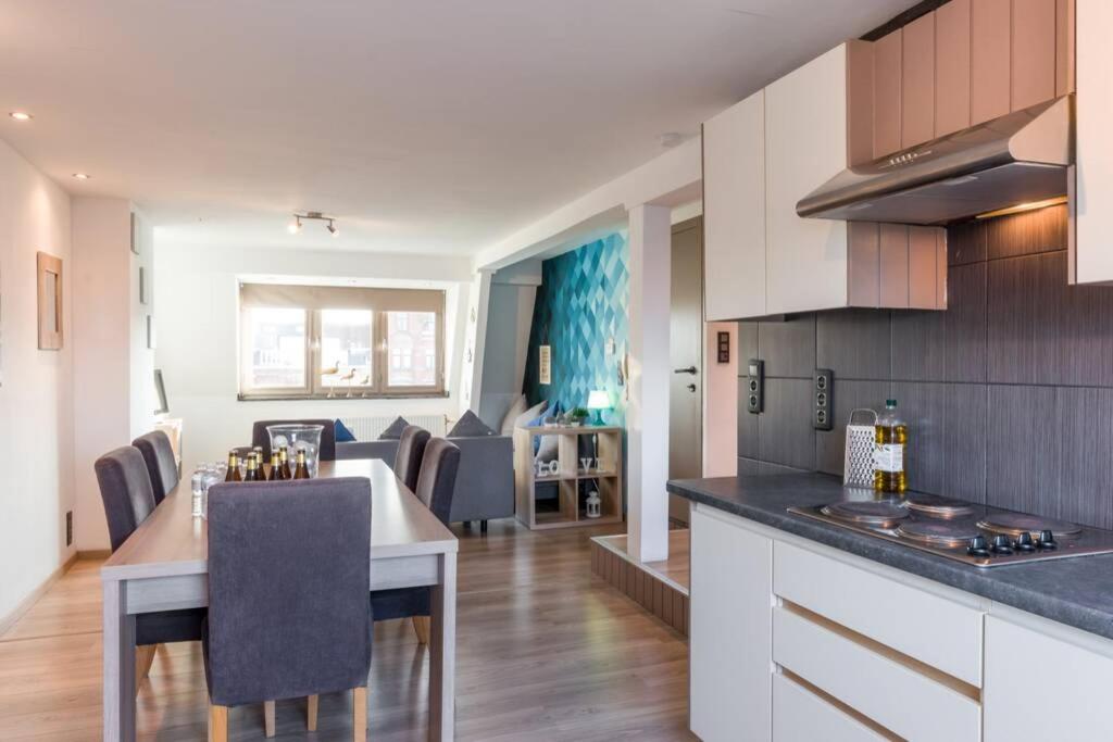 布鲁日Duplex appertement met zicht Damse vaart @ Brugge的厨房以及带桌椅的起居室。