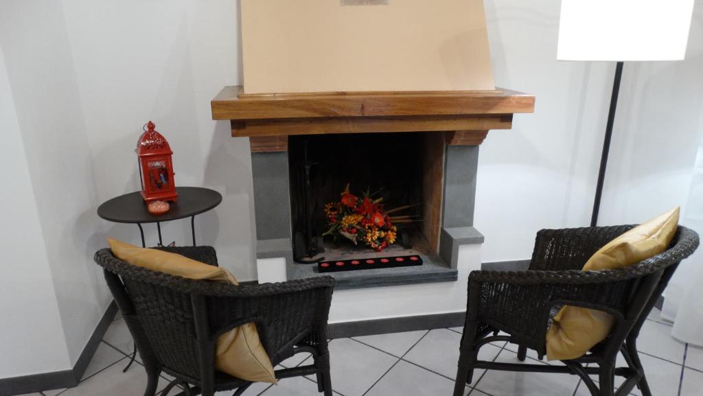 NicolaLUCAS LUXURY HOUSE的客厅设有壁炉和2把椅子