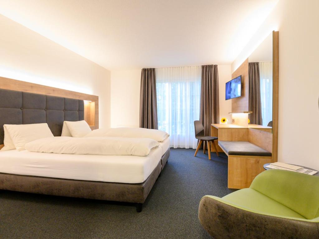 KriegstettenRomantik Hotel & Restaurant Sternen的配有一张床和一把椅子的酒店客房