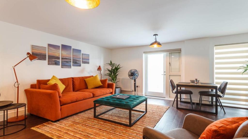 伯恩茅斯Stay@Coast的客厅配有橙色沙发和桌子