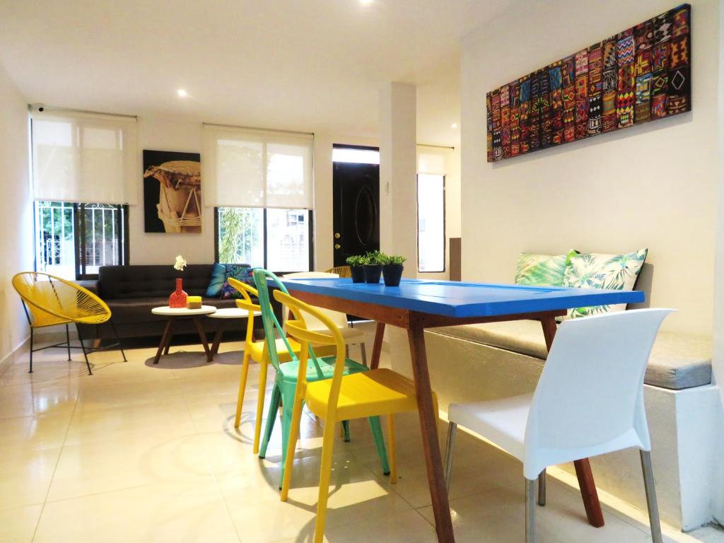 卡塔赫纳SAN JACINTO HOSTEL的一间配备有蓝色桌子和黄色椅子的用餐室