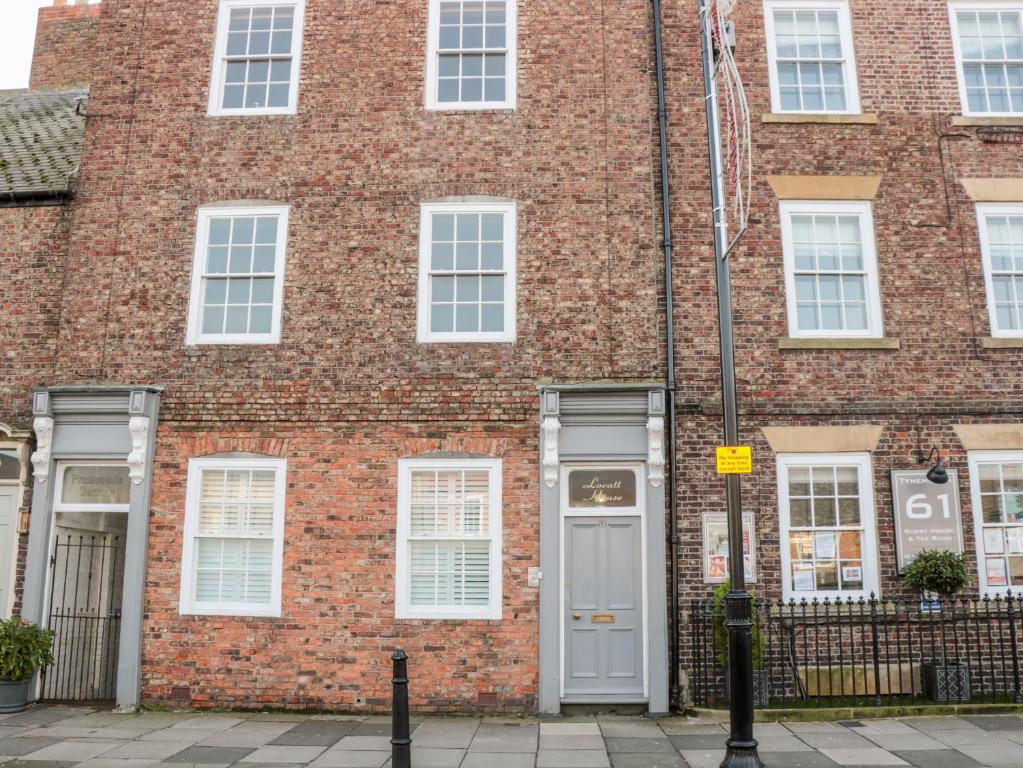 北希尔兹Tynemouth Village Penthouse的红砖建筑,有白色门
