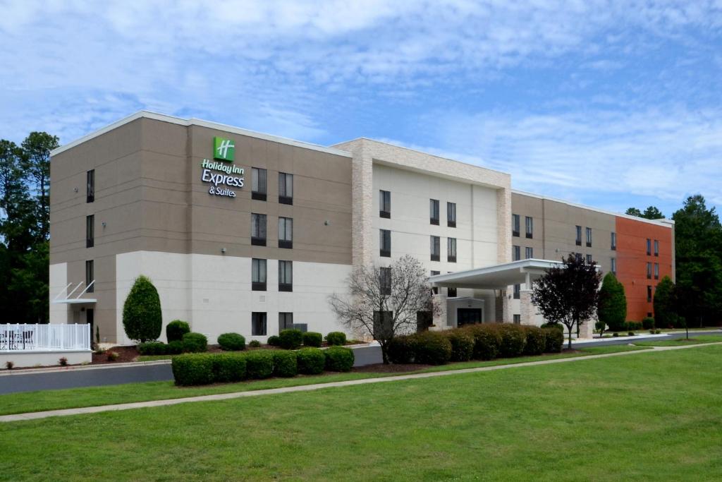 达拉姆Holiday Inn Express & Suites Raleigh Durham Airport at RTP, an IHG Hotel的酒店大楼前面设有草坪