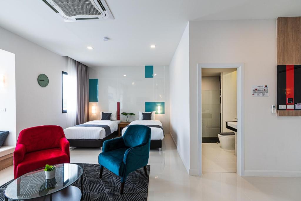 黎逸府The Hi Place的酒店客房带两张床和一张桌子以及椅子。