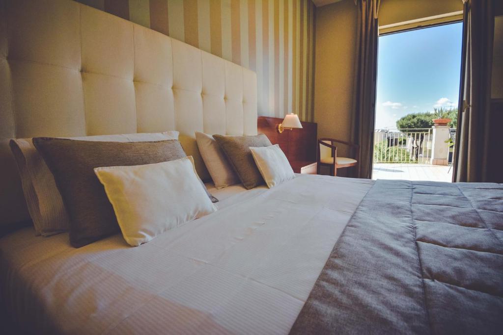 沃拉李奥内莎酒店的一张大床,位于带大窗户的房间里