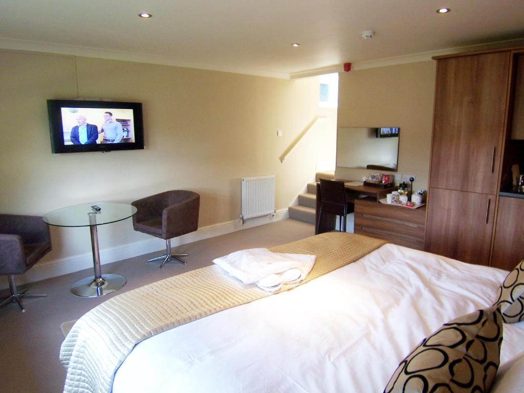 贝克韦尔Bagshaw Lodge的卧室配有一张床,墙上配有电视。