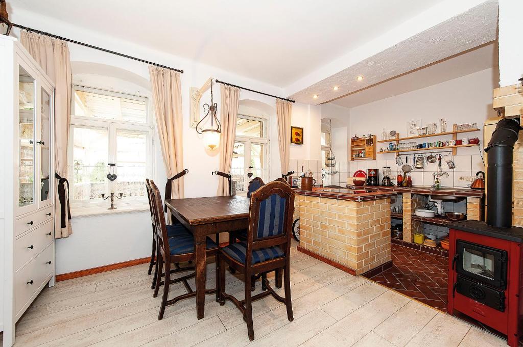 DohnaFerienwohnung Gans Auguste的厨房配有木桌和壁炉。