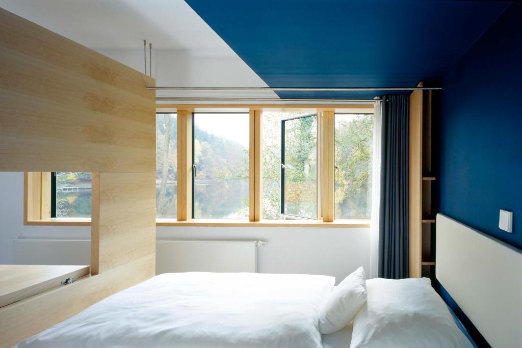 Ramsenseehaus forelle haeckenhaus的一间卧室设有一张床和蓝色的墙壁