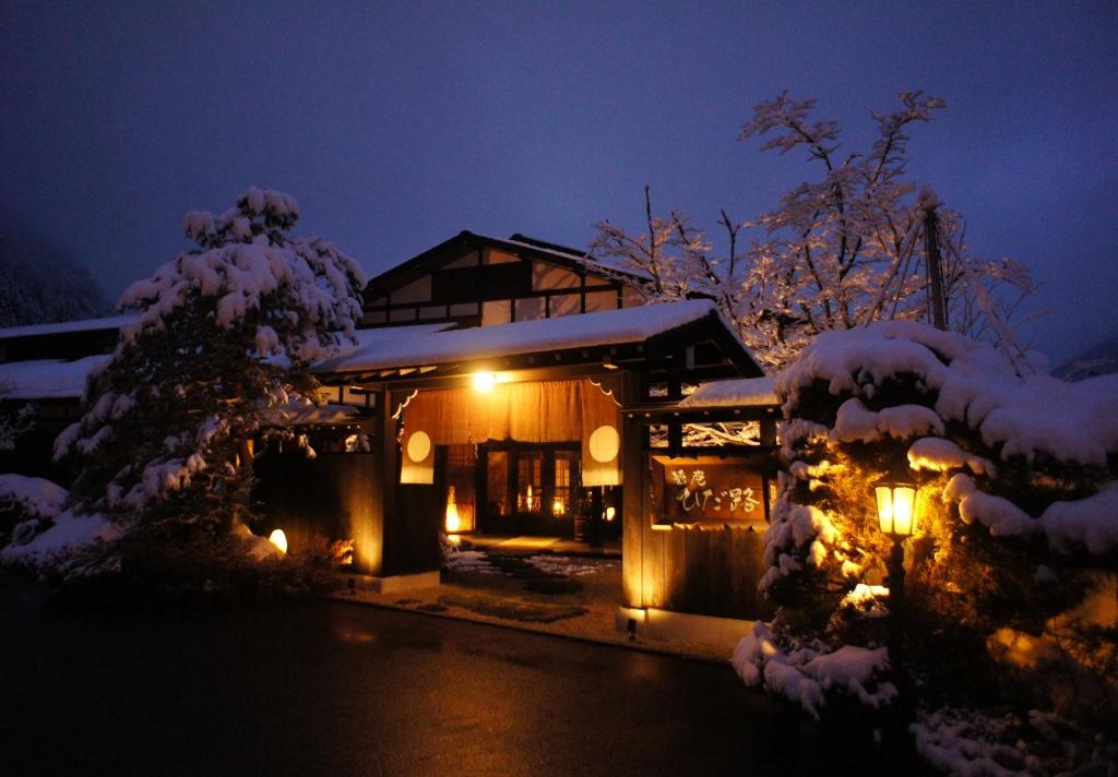 高山飞騨路传统日式旅馆（仅限成人入住）的雪覆盖的房屋,晚上有灯
