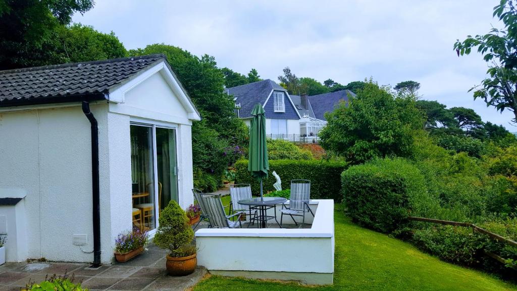 金塞尔Rocklands Cottage的白色的小房子,配有桌子和椅子
