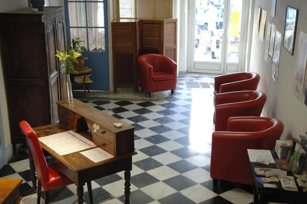 佩尔蒂库尔酒店的一间设有红色椅子、一张桌子和一张书桌的等候室