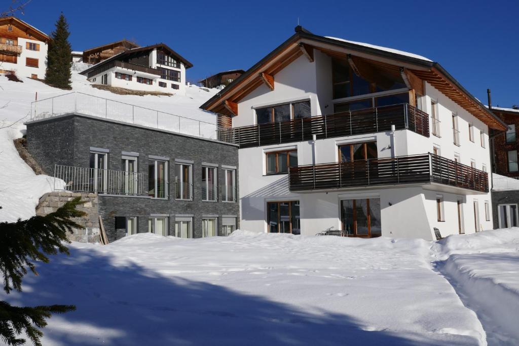 莱赫阿尔贝格Alpinikum Apartments的前面有雪的建筑