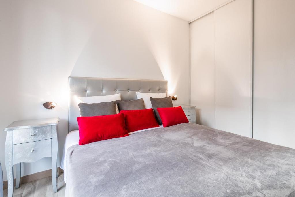蒙泰夫兰EDEN PARK LUXE DISNEY的白色卧室配有一张带红色枕头的大床