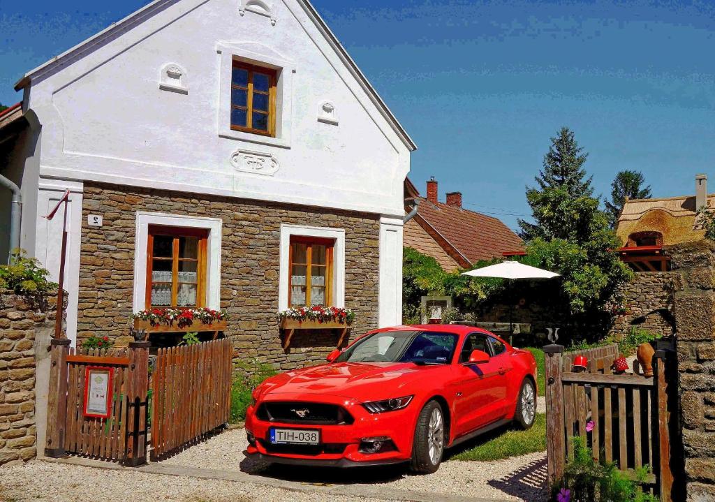 蒂豪尼B B Guesthouse TIHANY的停在房子前面的红色汽车