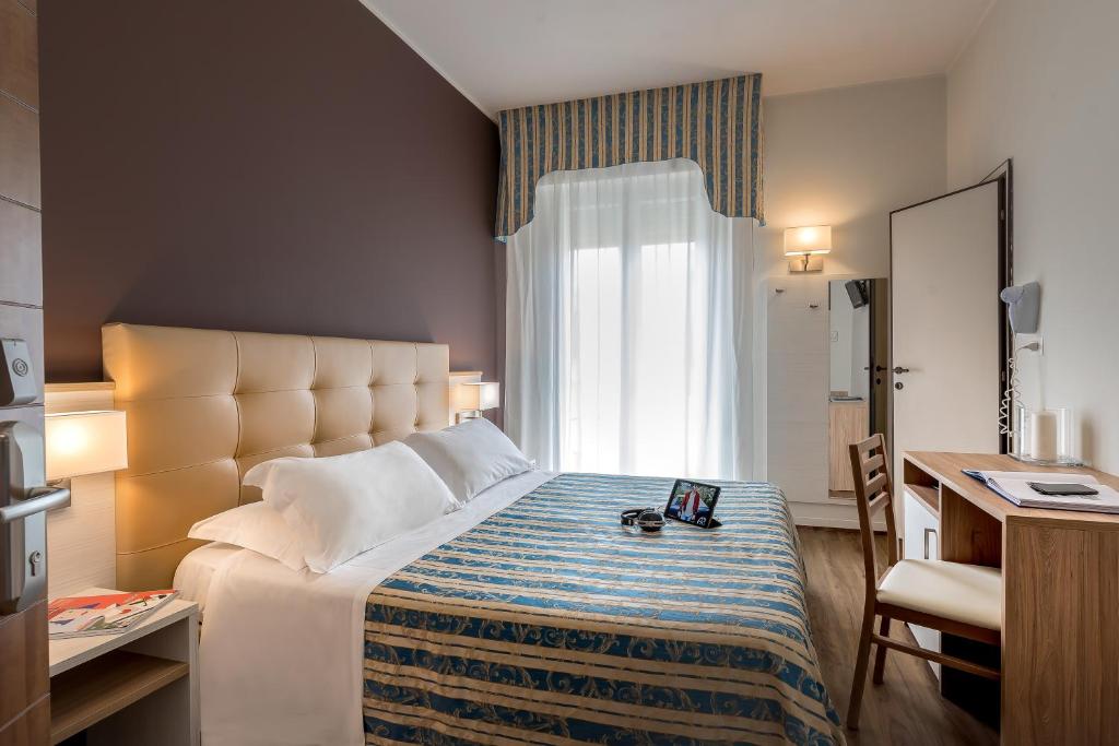 里米尼索尔米奥酒店的一间设有大床和窗户的酒店客房