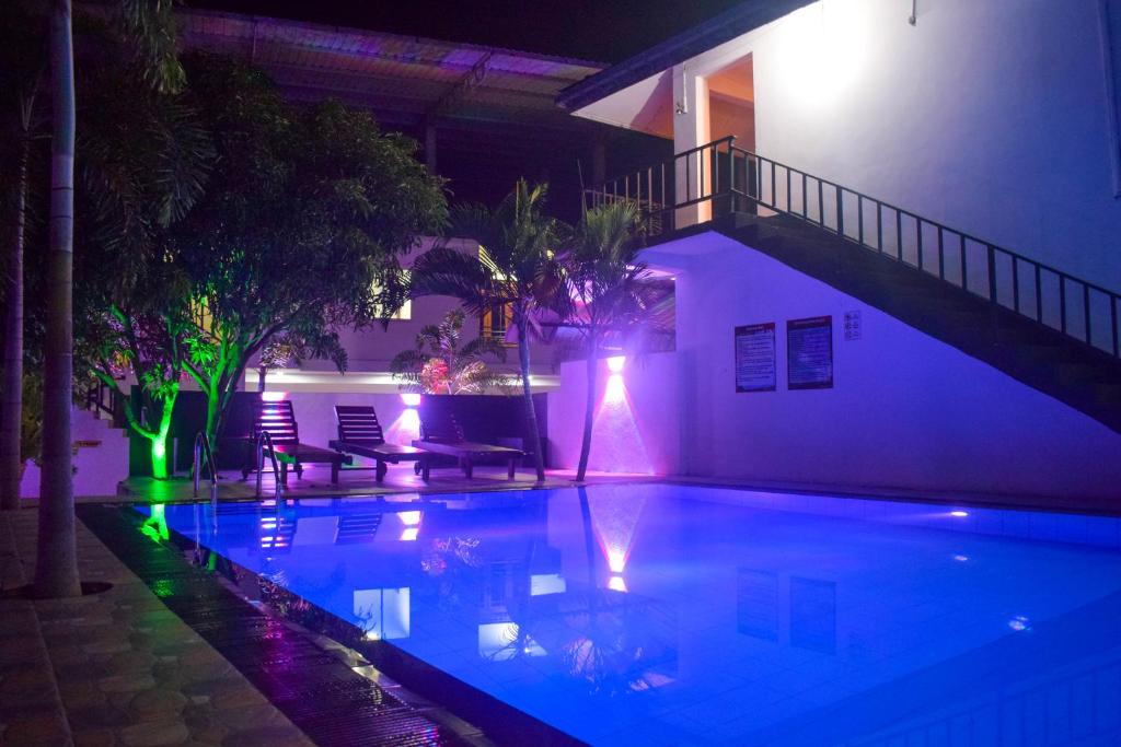 波隆纳鲁沃Lion Resort的游泳池在晚上点亮,灯光照亮