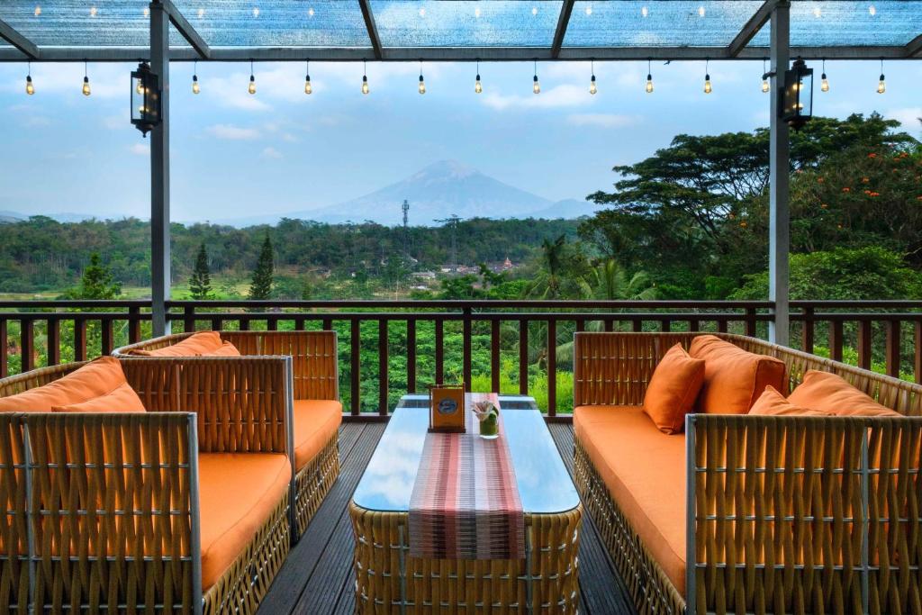 马格朗Puri Asri Hotel & Resort的露台配有两把椅子和一张桌子