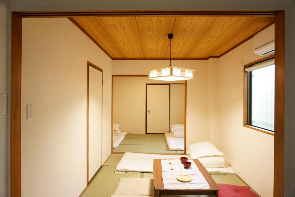 大阪SYOGA A house, next to natural park的一间设有桌子的房间和一间带走廊的房间