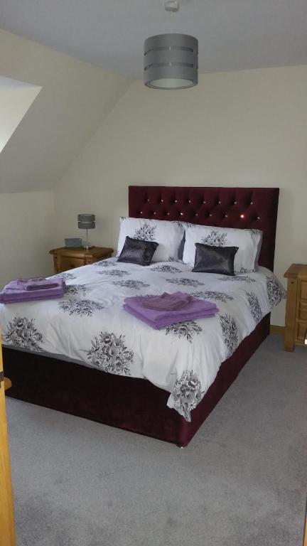 因弗内斯The Cobblers的一间卧室配有一张大床,铺有紫色和白色的床单。