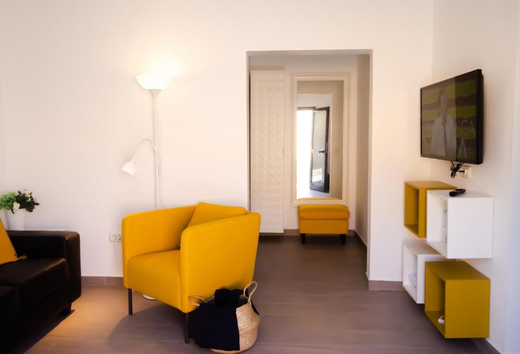 TigadayV.V. Casa Quintero的客厅配有黄色椅子和电视